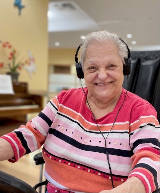 Female memory care resident listening to headphones