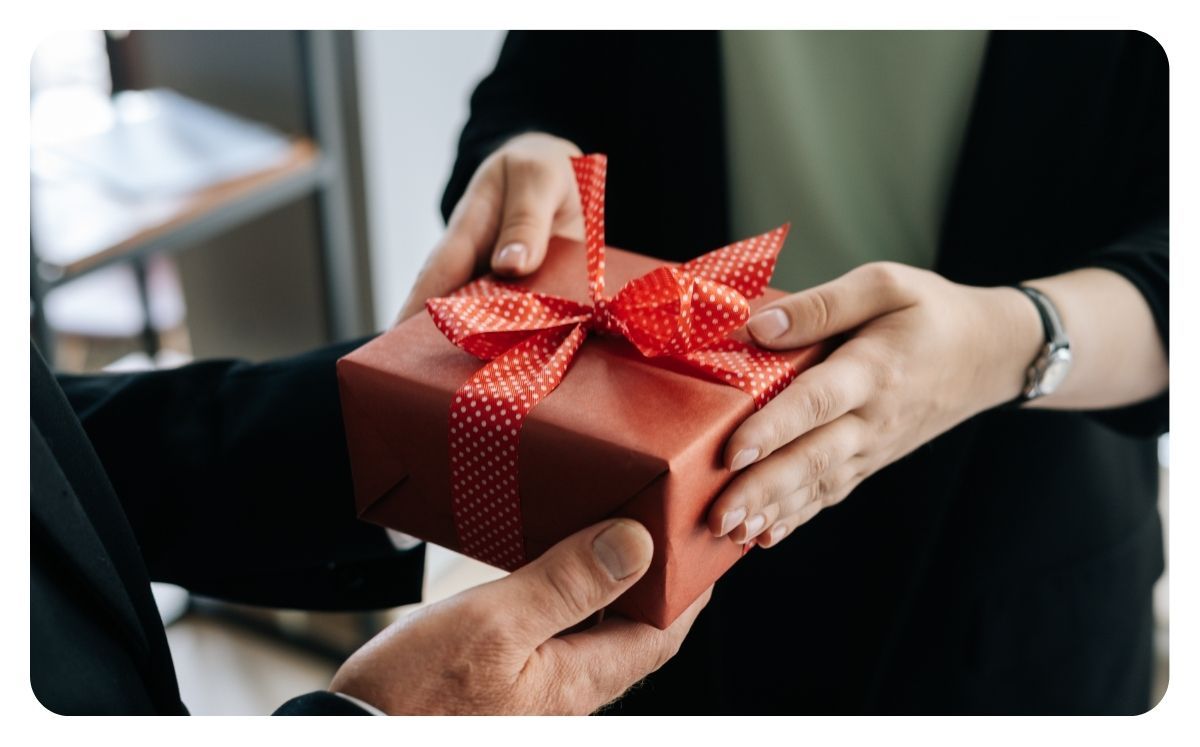 female hands giving gift to holder man